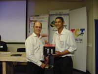 Mr Kobus Jansen van Rensburg (T-Systems) handing over the prize to the lucky draw winner